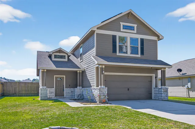 a view of a house with a yard and a garage