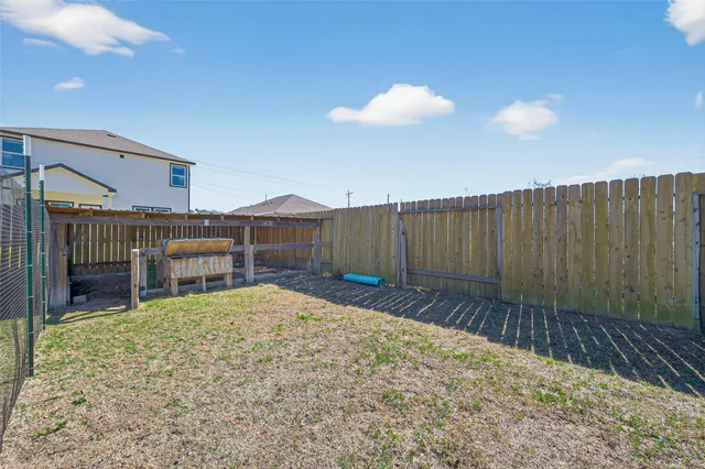 a view of backyard with wooden fence