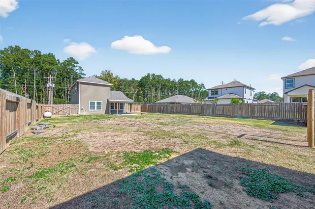 a view of a house with backyard and tree
