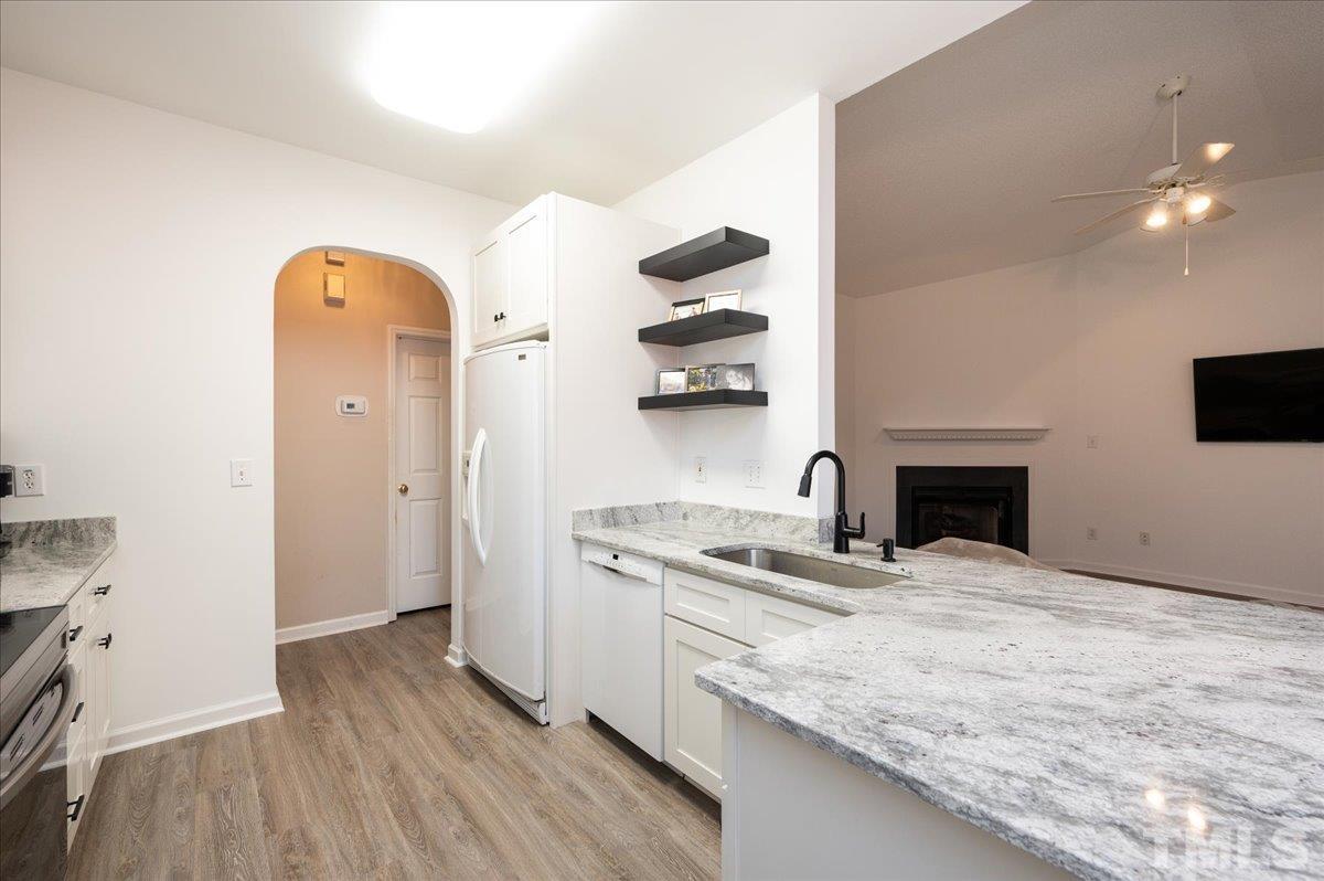 8616 Neuse Stone Drive Raleigh, NC 27616 - Photo 13 of 24 a kitchen with stainless steel appliances granite countertop a sink a stove and a wooden floors