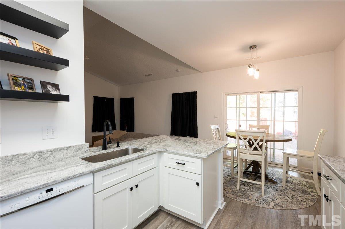 8616 Neuse Stone Drive Raleigh, NC 27616 - Photo 16 of 24 a kitchen with a sink cabinets and dining table chair