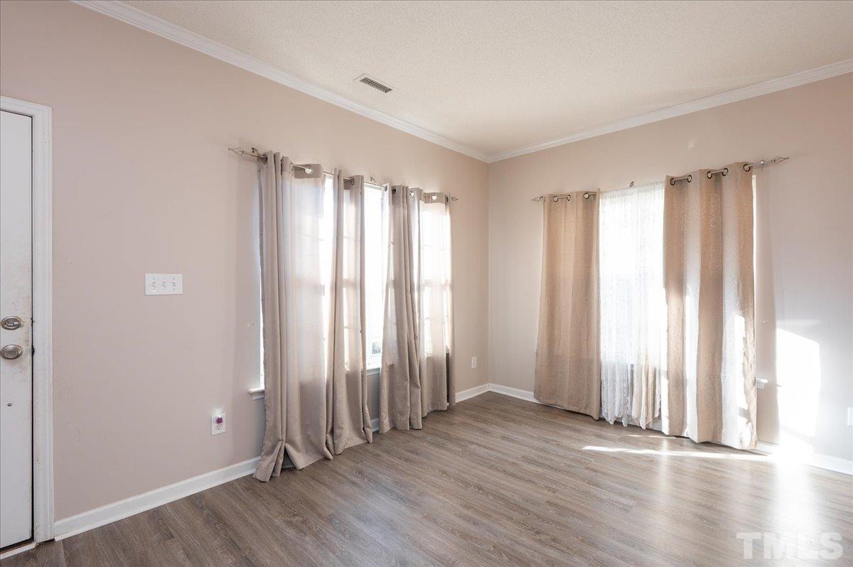 8616 Neuse Stone Drive Raleigh, NC 27616 - Photo 4 of 24 an empty room with wooden floor and a window