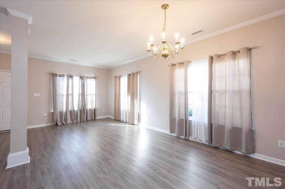 8616 Neuse Stone Drive Raleigh, NC 27616 - Photo 7 of 24 an empty room with wooden floor and windows