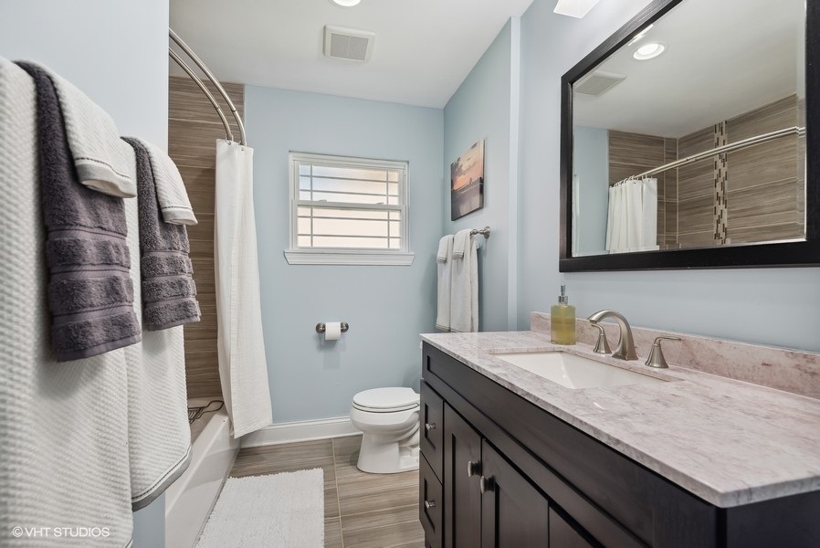 537 Romona Road Wilmette, IL 60091 - Photo 18 of 35 a bathroom with a granite countertop sink a toilet a mirror and shower