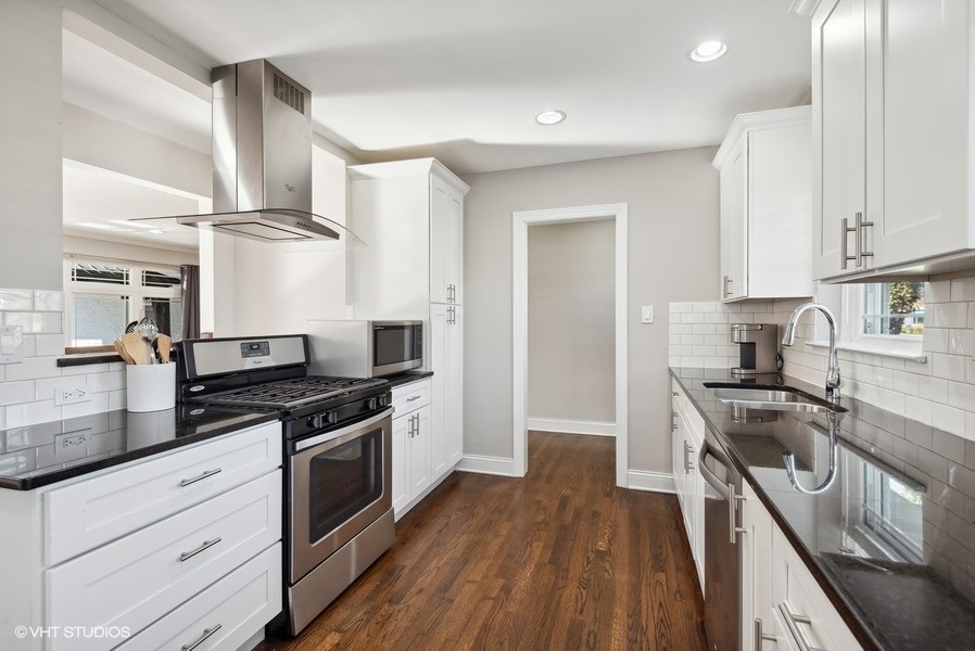 537 Romona Road Wilmette, IL 60091 - Photo 9 of 35 a kitchen with granite countertop wooden floor stainless steel appliances and sink