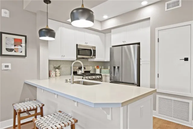 a kitchen with stainless steel appliances a refrigerator sink and microwave