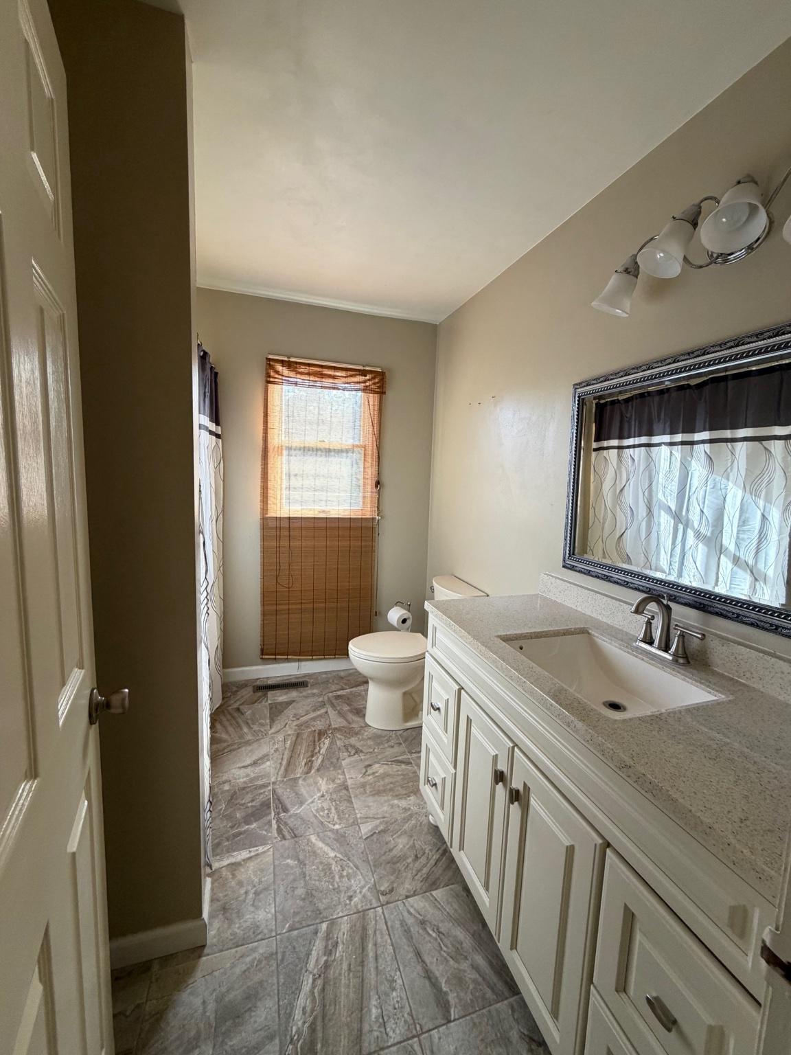 119 Constitution Avenue Reading, PA 19606 - Photo 8 of 15 a bathroom with a double vanity sink toilet mirror and window