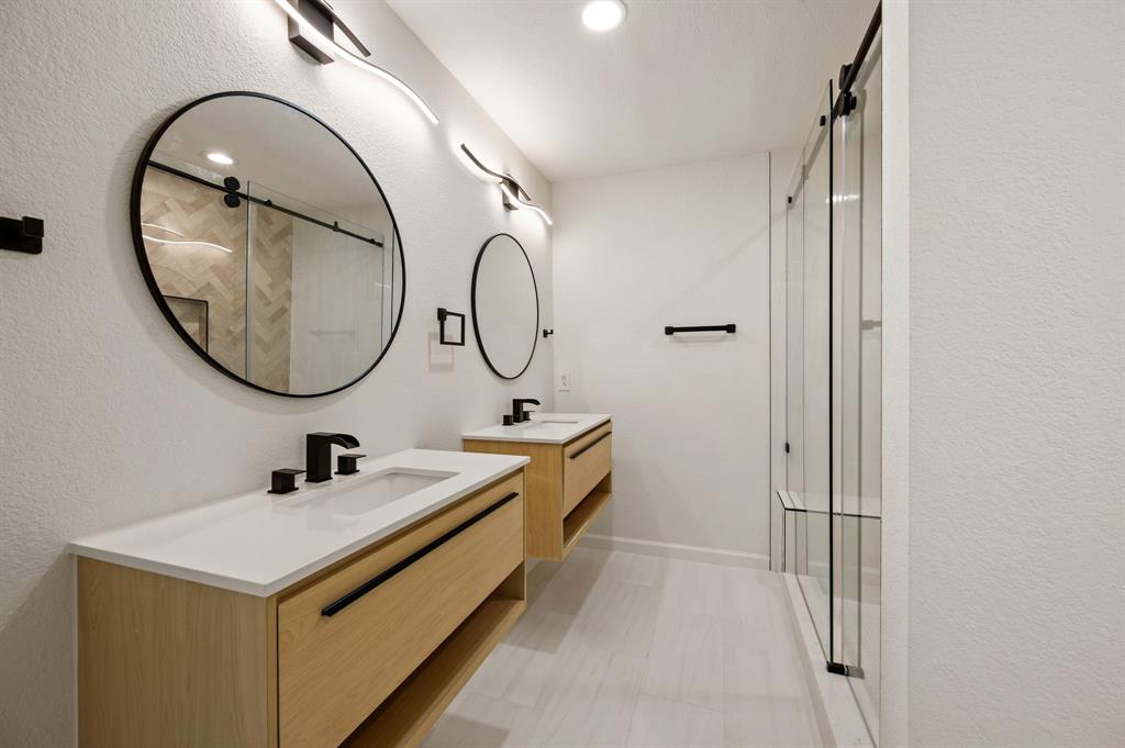 5009 Milam Street Dallas, TX 75206 - Photo 18 of 35 Bathroom with a stall shower, two vanities, a textured wall, and recessed lighting