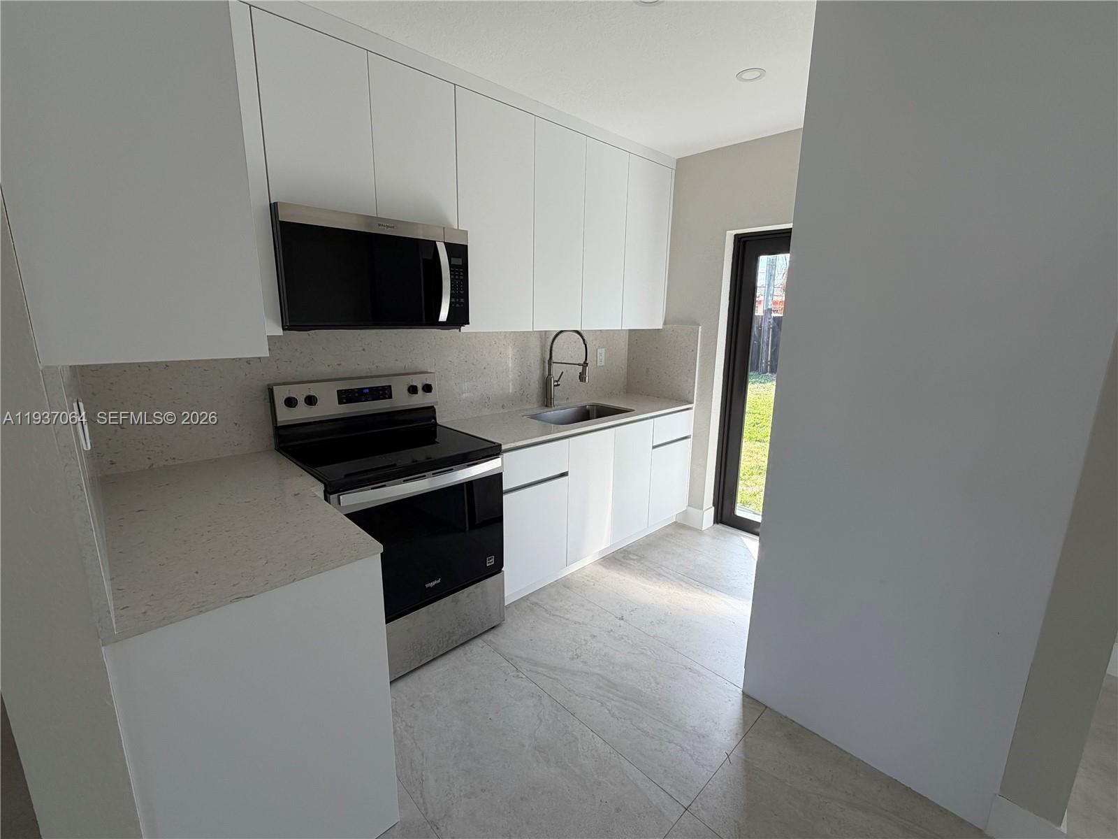 7330 Southwest 11th Street, Unit 7330 Miami, FL 33144 - Photo 7 of 25 a kitchen with a sink and a stove top oven
