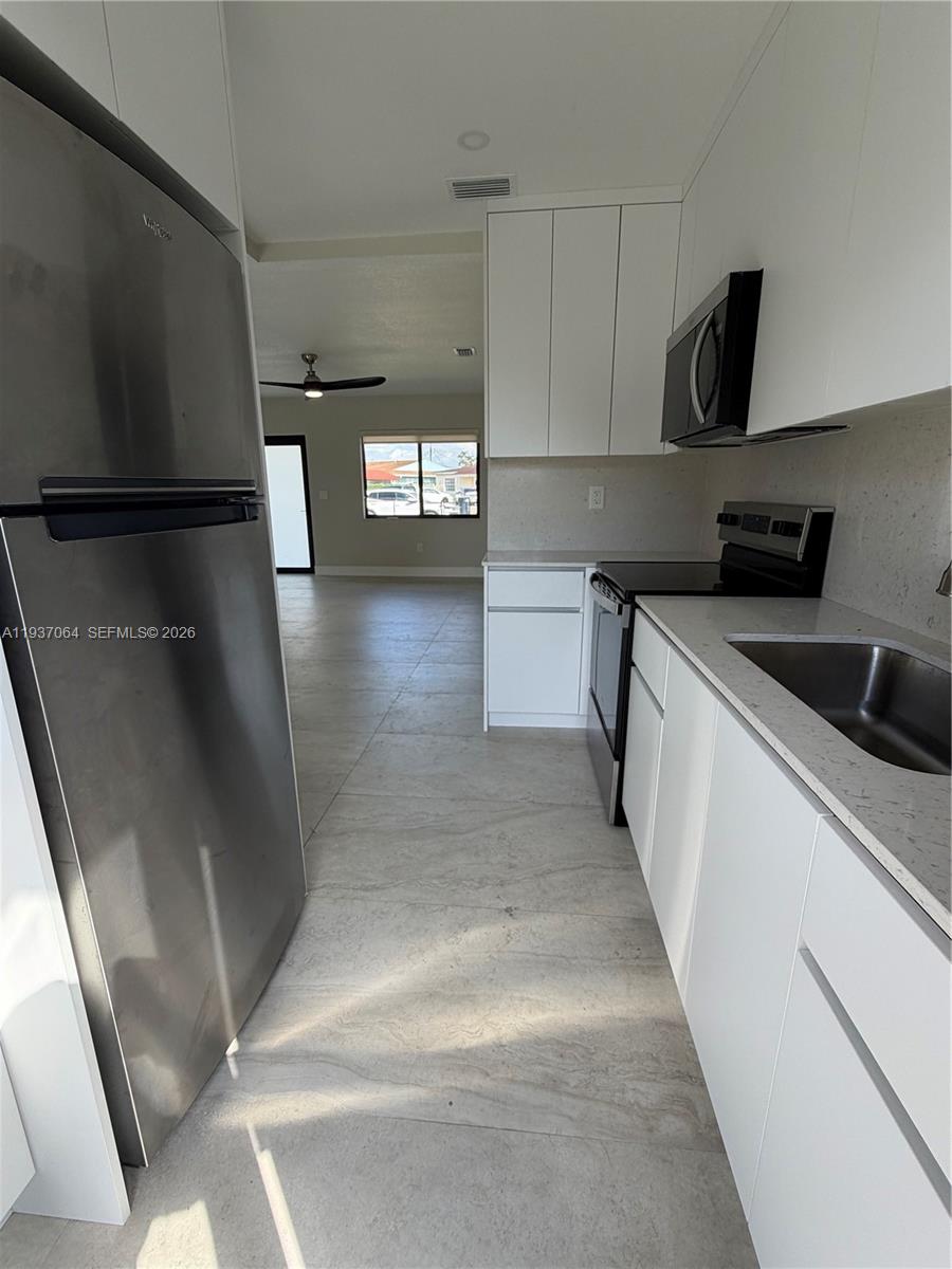 7330 Southwest 11th Street, Unit 7330 Miami, FL 33144 - Photo 9 of 25 a view of a kitchen with a sink and dishwasher stove top oven