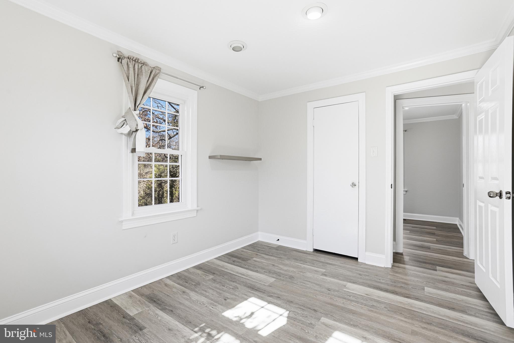 8324 Newland Road Warsaw, VA 22572 - Photo 19 of 31 an empty room with wooden floor and windows