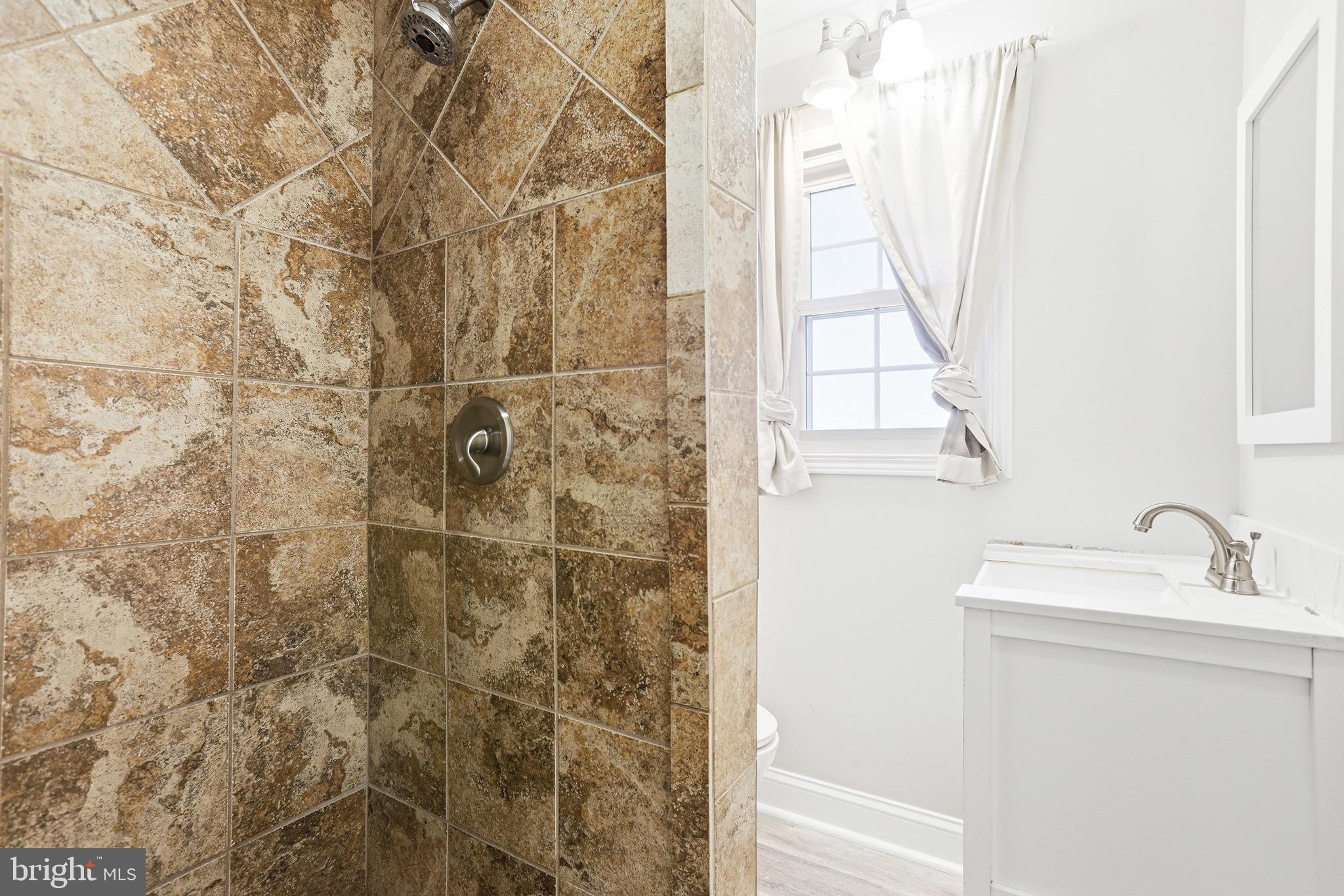 8324 Newland Road Warsaw, VA 22572 - Photo 23 of 31 a bathroom with a sink a mirror and a shower