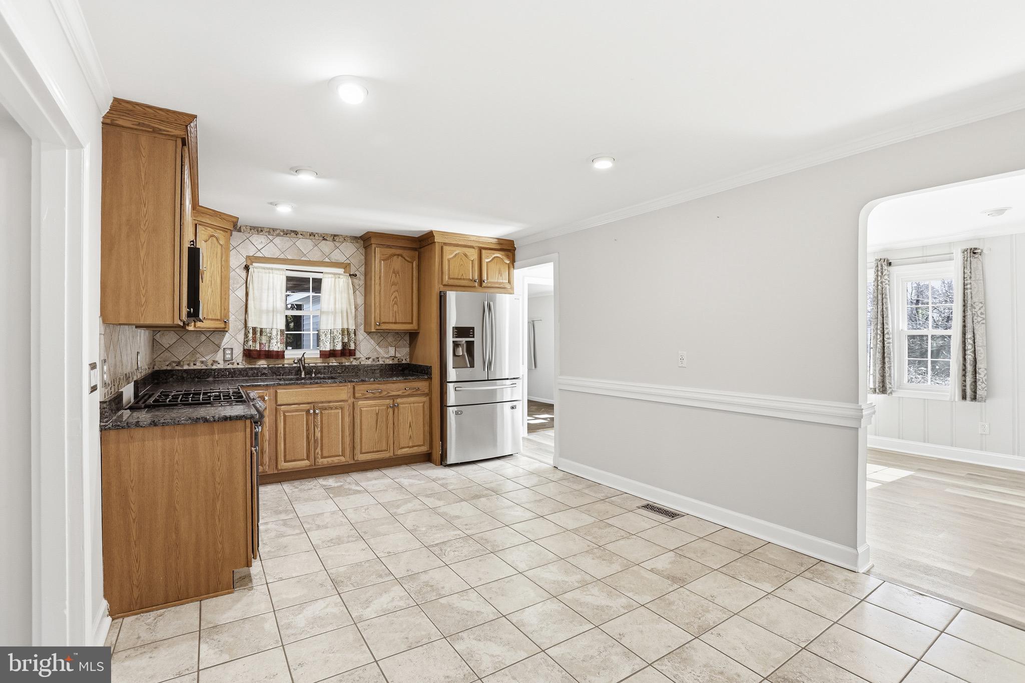 8324 Newland Road Warsaw, VA 22572 - Photo 7 of 31 a kitchen with granite countertop a refrigerator and a stove top oven