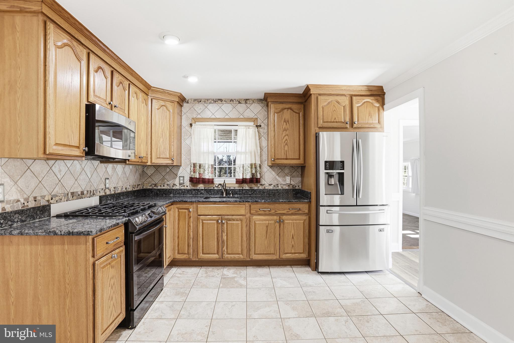 8324 Newland Road Warsaw, VA 22572 - Photo 9 of 31 a kitchen with a refrigerator sink and cabinets
