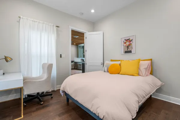 a bedroom with a bed and wooden floor
