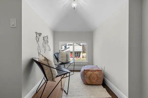 a bedroom with a bed a table and wooden floor