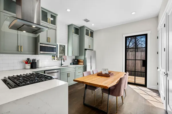 a kitchen with stainless steel appliances a stove a sink and a refrigerator