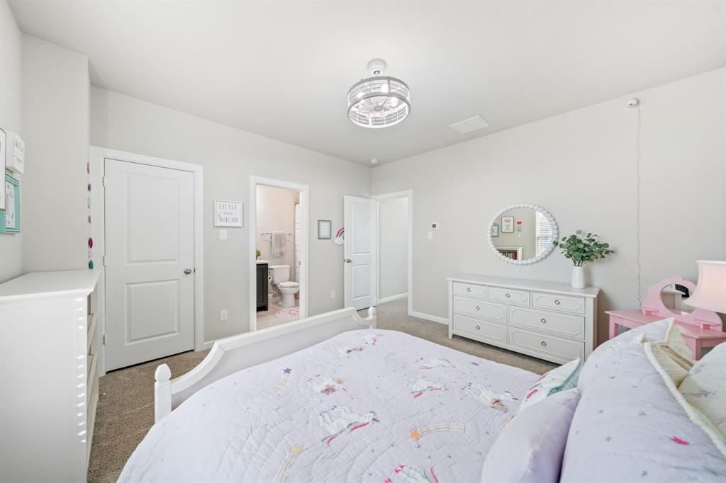 16548 Indiangrass Road Frisco, TX 75033 - Photo 22 of 39 a bedroom with a bed and a chandelier