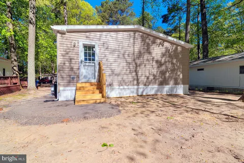 a view of a big room with wooden floor and windows