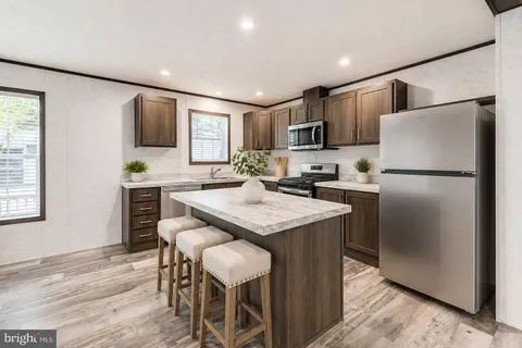 a kitchen with kitchen island granite countertop wooden floors and stainless steel appliances