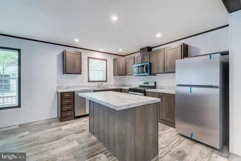 a kitchen with stainless steel appliances granite countertop a sink refrigerator and microwave