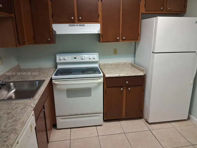 a kitchen with a stove top oven and cabinets