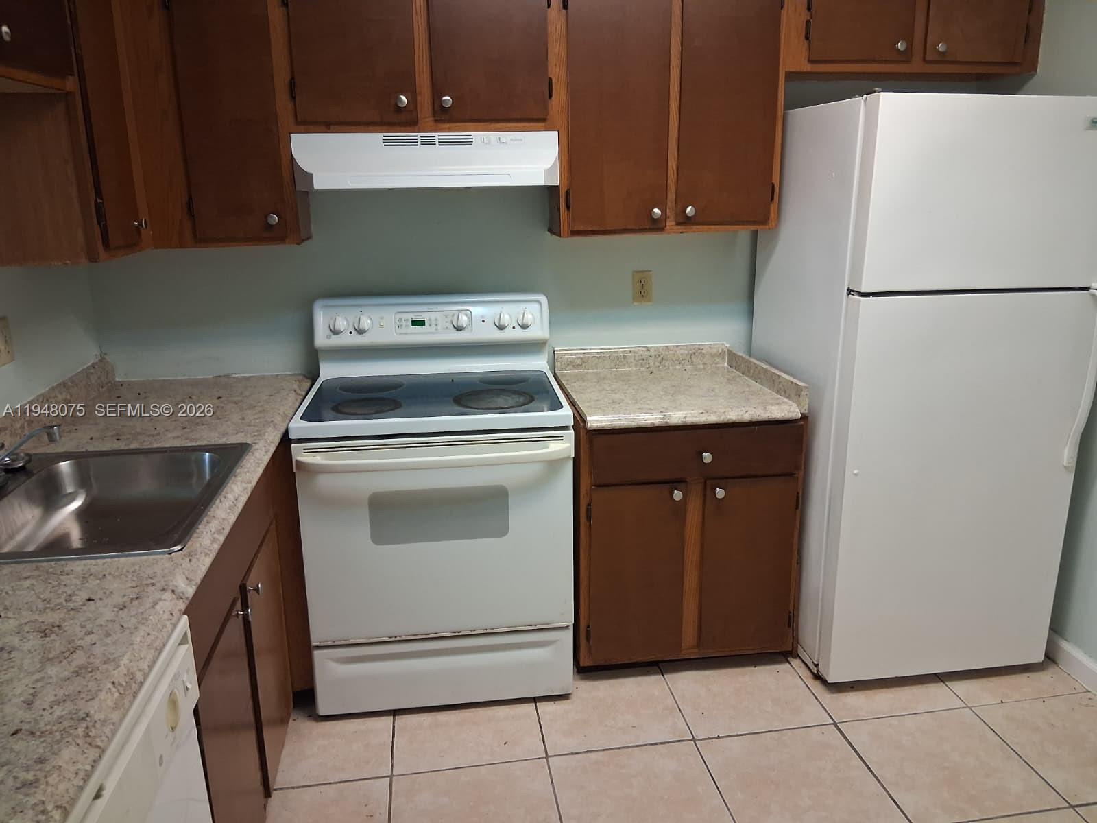 19791 Southwest 114th Avenue, Unit 135 Miami, FL 33157 - Photo 2 of 9 a kitchen with a stove top oven and cabinets