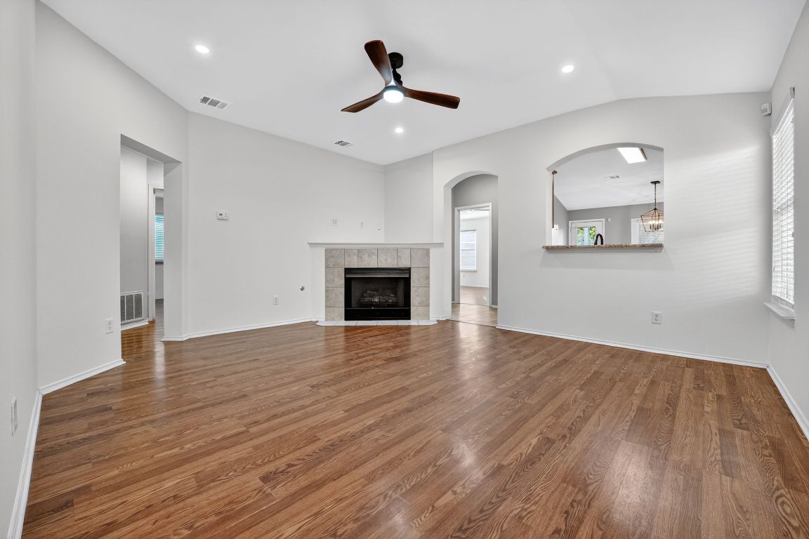 1502 McDowell Bend Leander, TX 78641 - Photo 1 of 31 an empty room with wooden floor a ceiling fan and windows