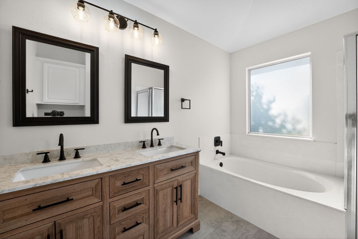 1502 McDowell Bend Leander, TX 78641 - Photo 28 of 31 a bathroom with 2 sink tub and a mirror