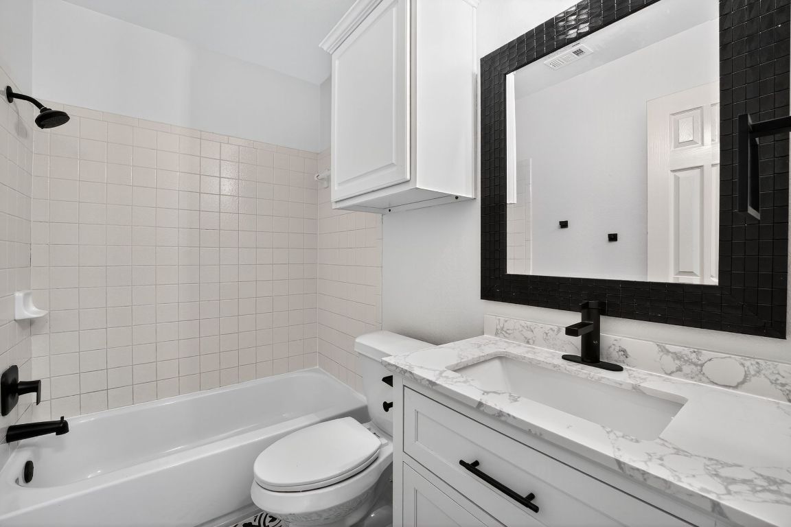 1502 McDowell Bend Leander, TX 78641 - Photo 29 of 31 a bathroom with a sink a toilet and a bathtub