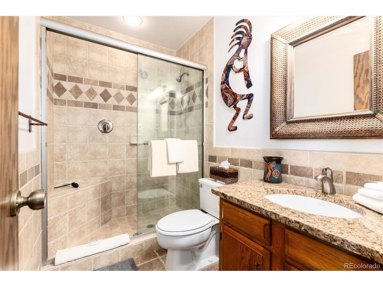 490 Kings Crossing Road, Unit 631 Winter Park, CO 80482 - Photo 31 of 43 a bathroom with a granite countertop sink a toilet and a shower
