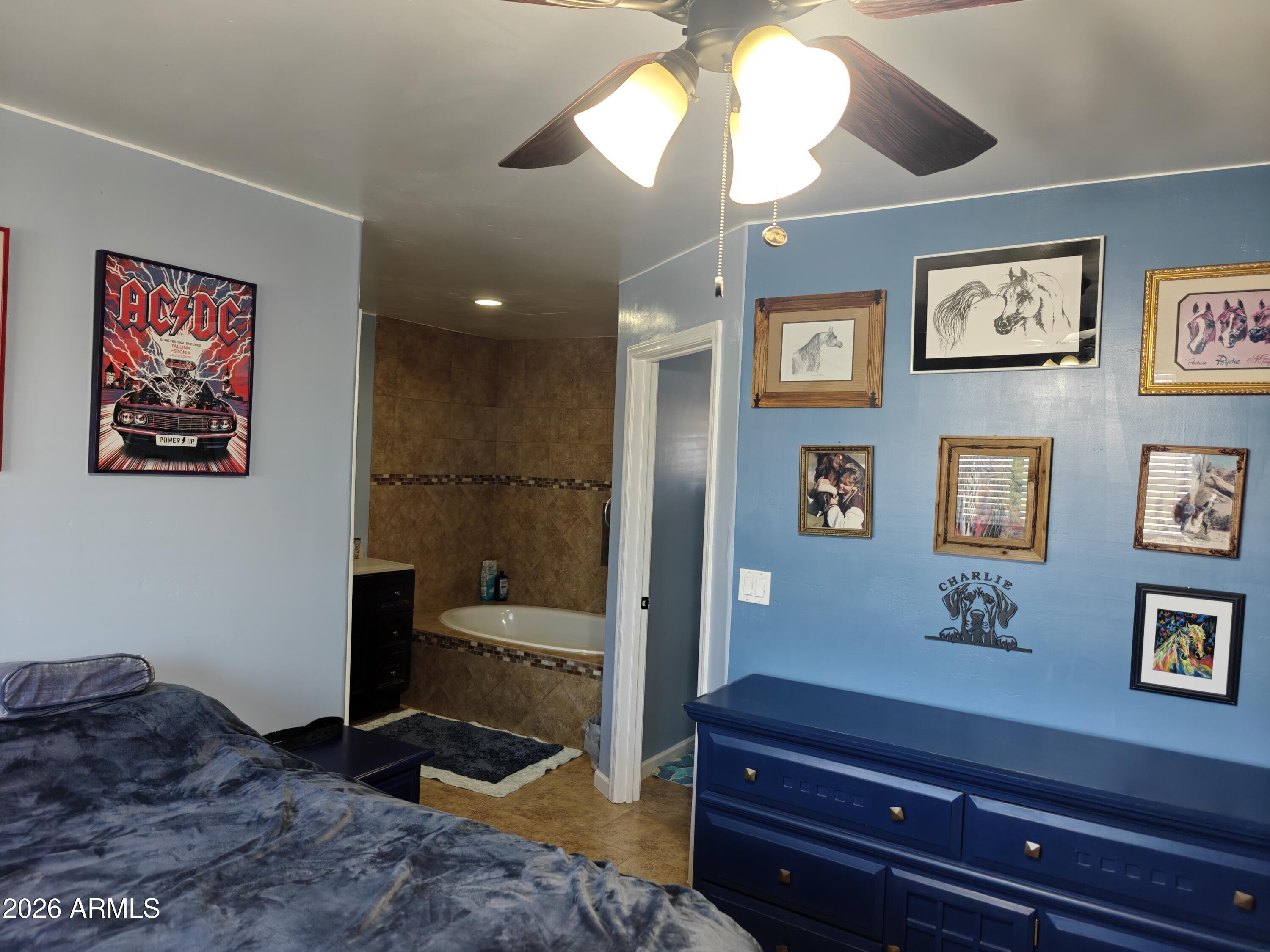 2417 West Roughrider Road New River, AZ 85087 - Photo 11 of 61 a spacious bedroom with a bed and a chandelier