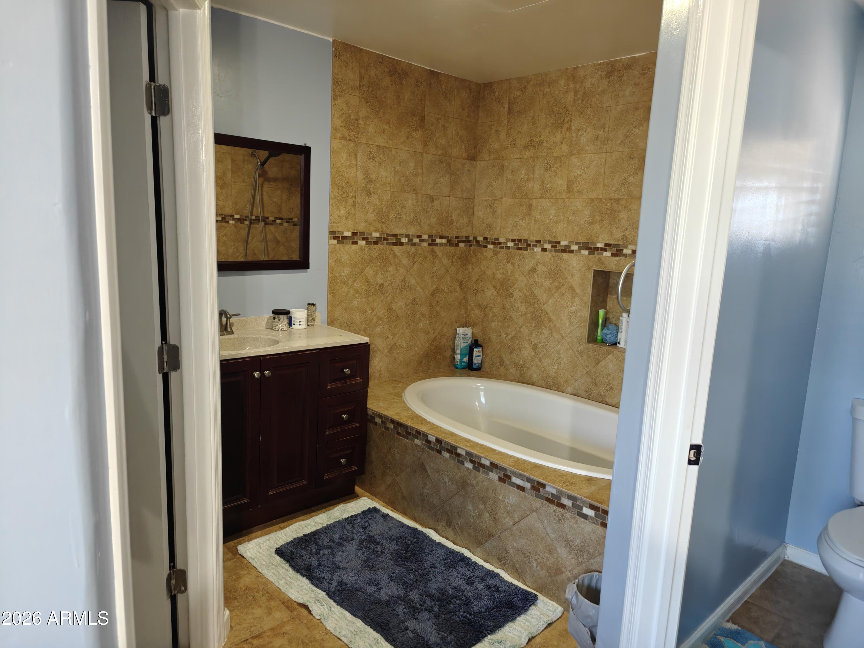 2417 West Roughrider Road New River, AZ 85087 - Photo 13 of 61 a bathroom with a tub sink and mirror