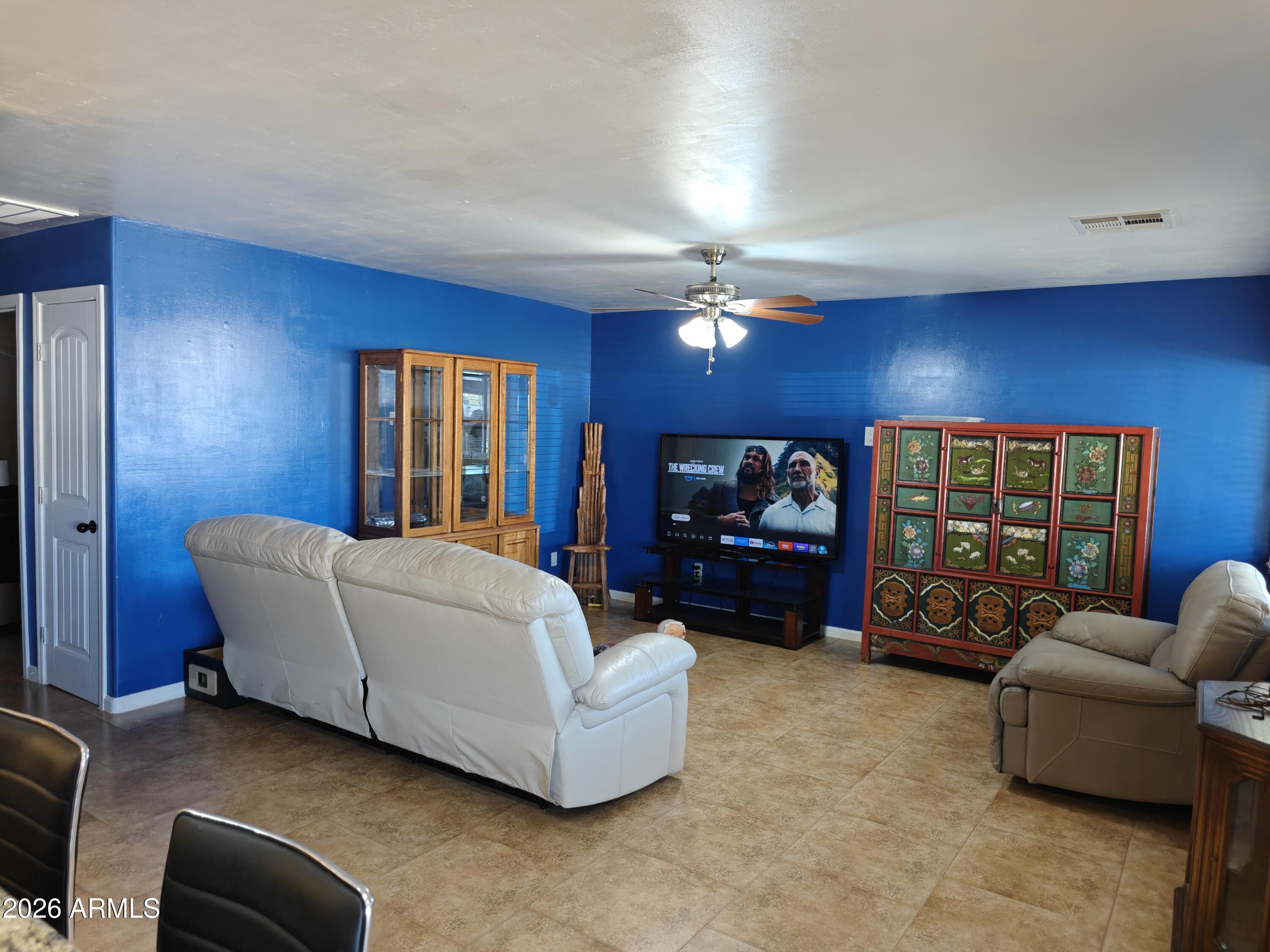2417 West Roughrider Road New River, AZ 85087 - Photo 4 of 61 a living room with furniture and a flat screen tv