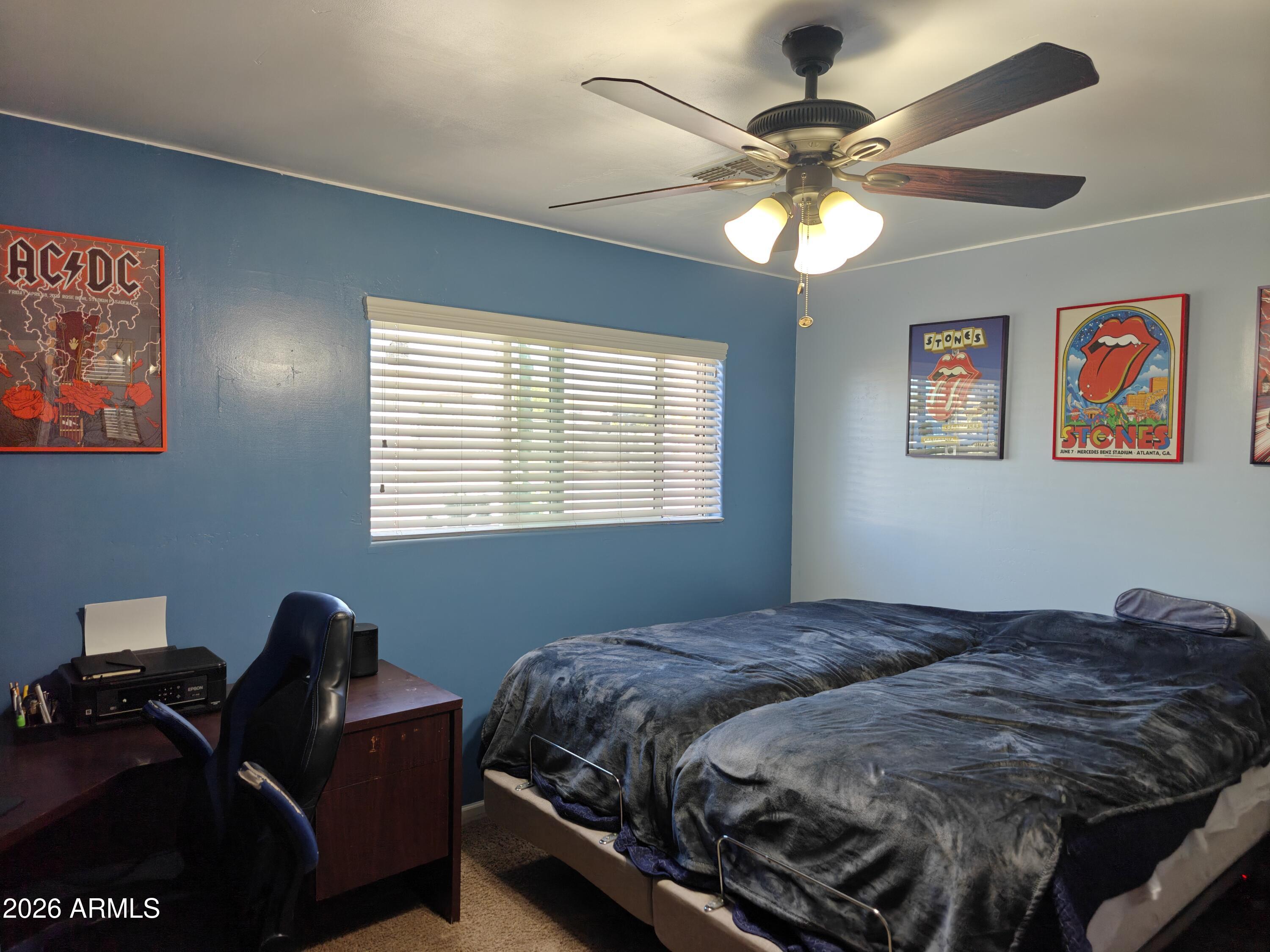 2417 West Roughrider Road New River, AZ 85087 - Photo 10 of 61 a bedroom with a bed and a chandelier
