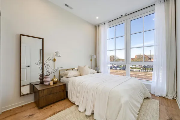 a bedroom with a bed and large window