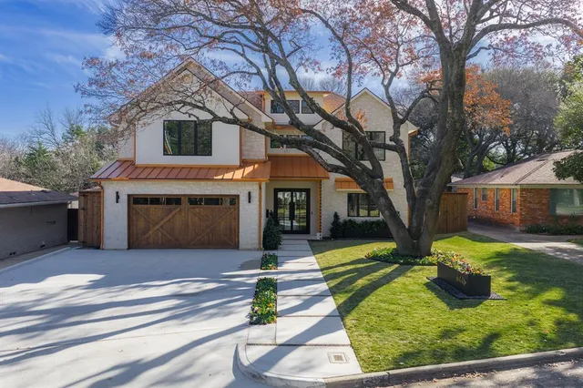 a front view of house with yard and trees in the background