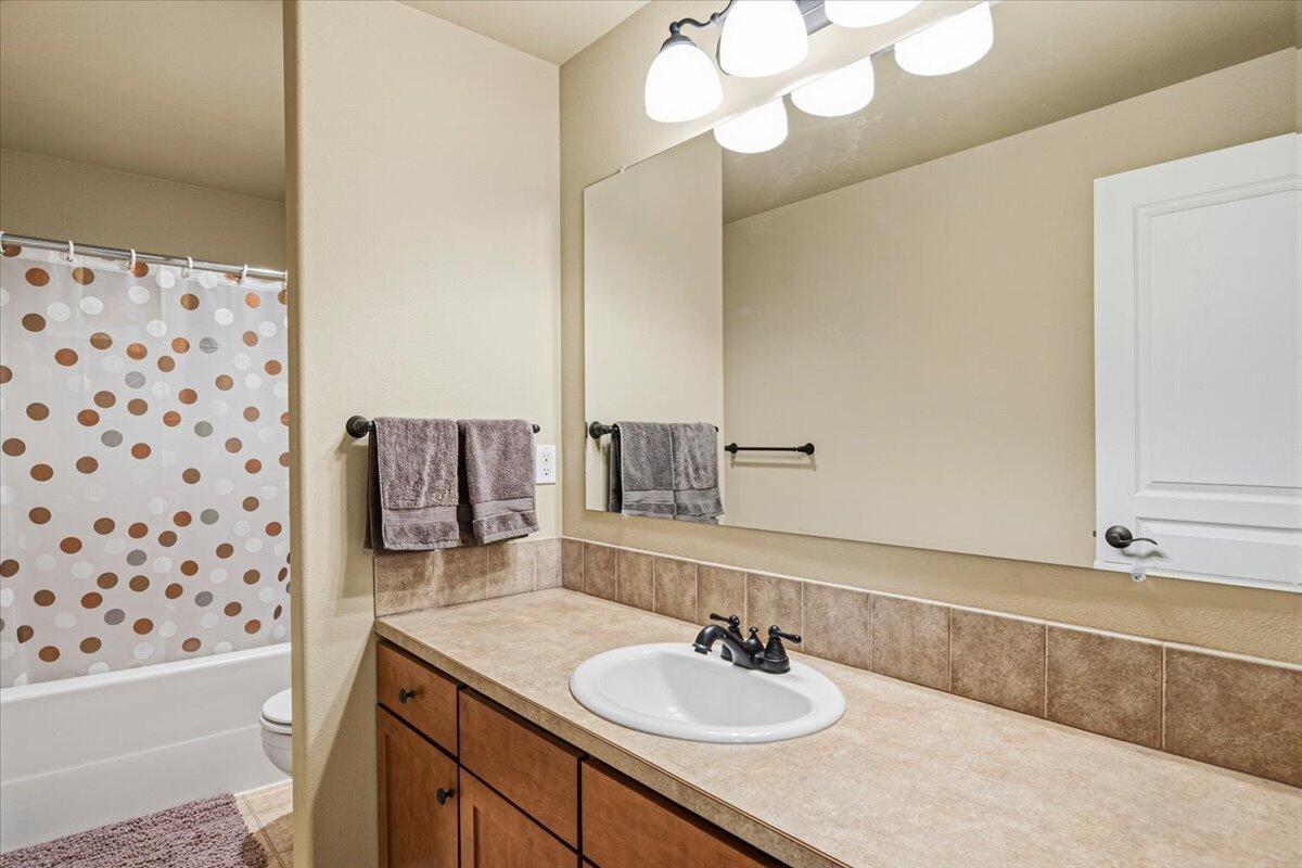 1339 Southwest Rimrock Way Redmond, OR 97756 - Photo 15 of 26 a bathroom with a sink a mirror and a shower