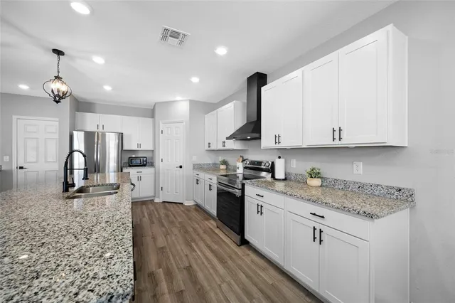 a dining room with furniture a chandelier and wooden floor