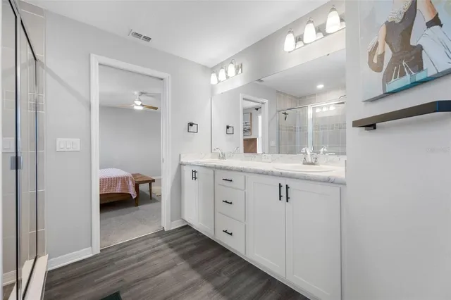 an empty room with windows and ceiling fan