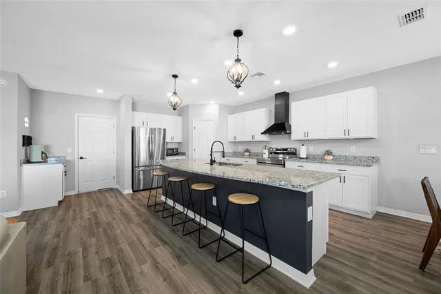 a kitchen with granite countertop a sink stainless steel appliances and cabinets