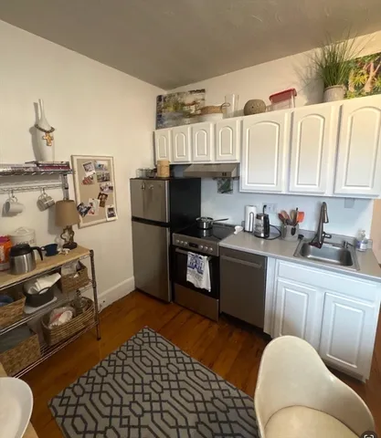 a kitchen with granite countertop a refrigerator stove top oven and sink