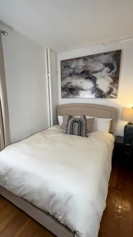 a bedroom with a bed and painting on the wall