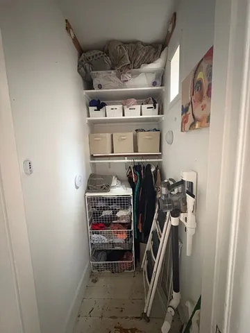 a view of walk in closet with clothes