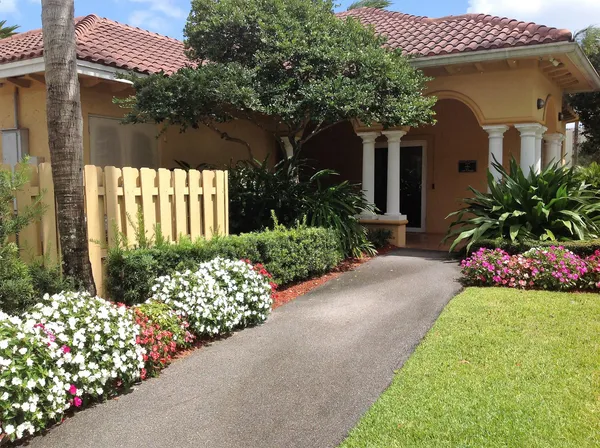 a front view of a house having a garden