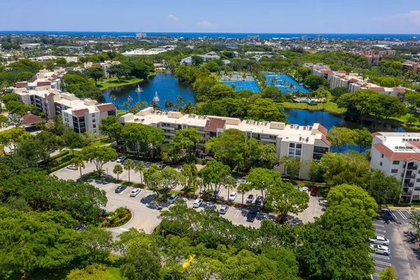 an aerial view of residential houses with outdoor space and trees
