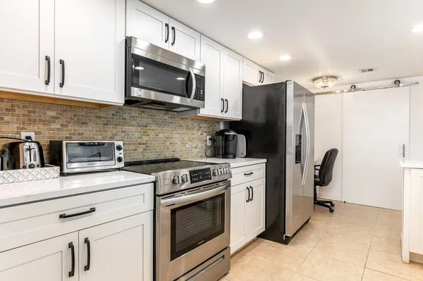 a kitchen with stainless steel appliances a stove microwave and refrigerator