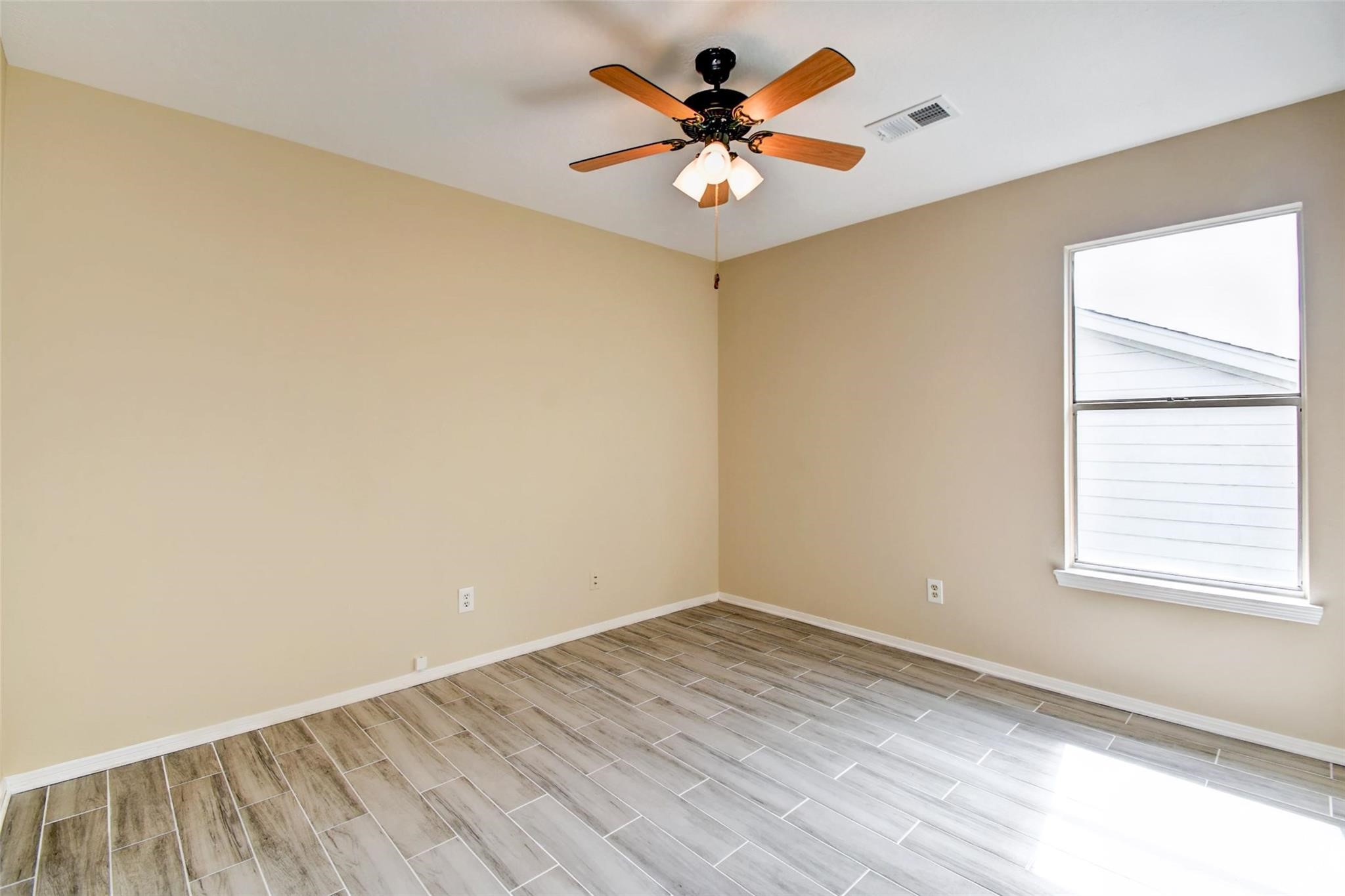 16811 Anna Green Street Houston, TX 77084 - Photo 22 of 27 an empty room with a window and a fan