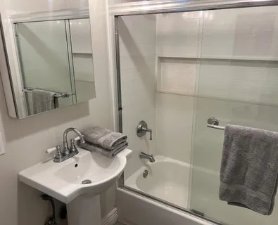 a bathroom with a sink and mirror with bathtub