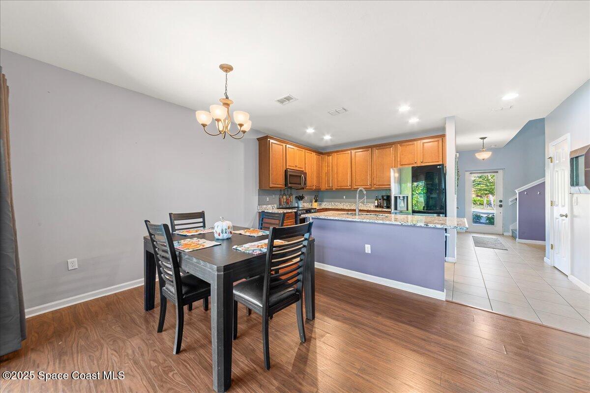 1345 Lara Circle, Unit 102 Rockledge, FL 32955 - Photo 13 of 34 a kitchen with stainless steel appliances granite countertop a kitchen island hardwood floor and a view of living room